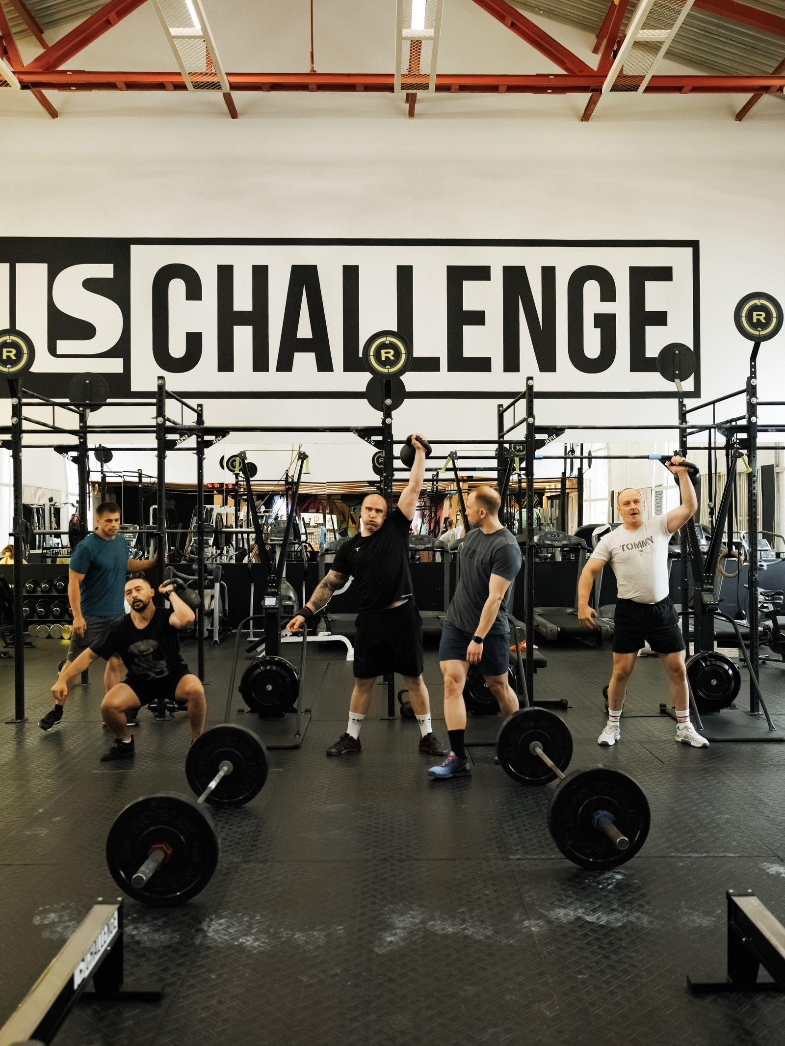Атлеты выполняют упражнения со штангой в зале Ils-Challenge